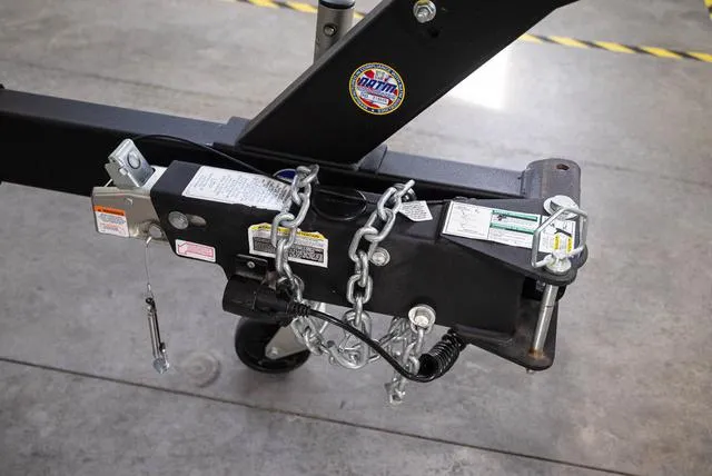 Slide: The Image of Trailer hitch of 2024 Yamaha Boats 255XE with safety chains and labels. - 33