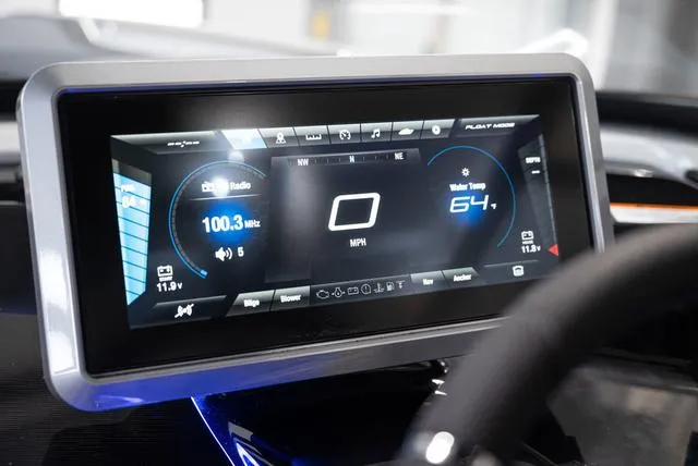 Slide: The Image of 2024 Yamaha Boats 255XE dashboard display showing speed, radio, and water temperature. - 7