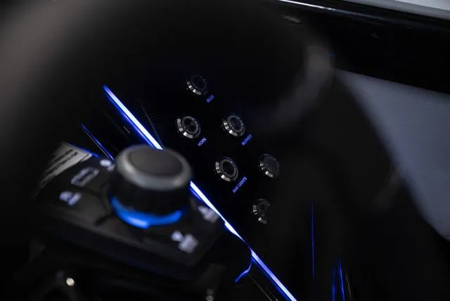 Slide: The Image of Close-up of 2024 Yamaha Boats 255XE dashboard with illuminated controls and buttons. - 8