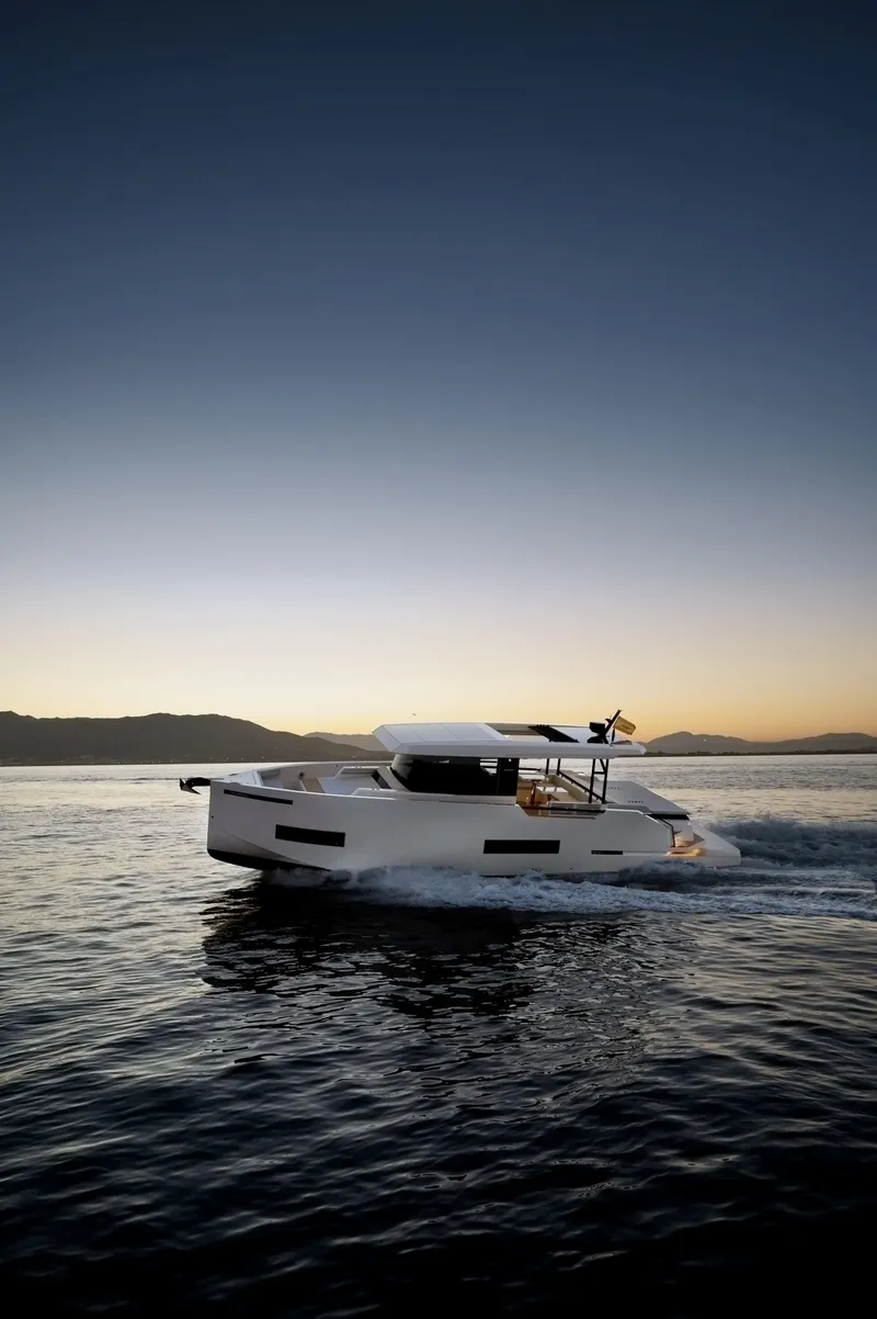 Slide: The Image of 2025 De Antonio Yachts D50 Coupé cruising at sunset on open water. - 7