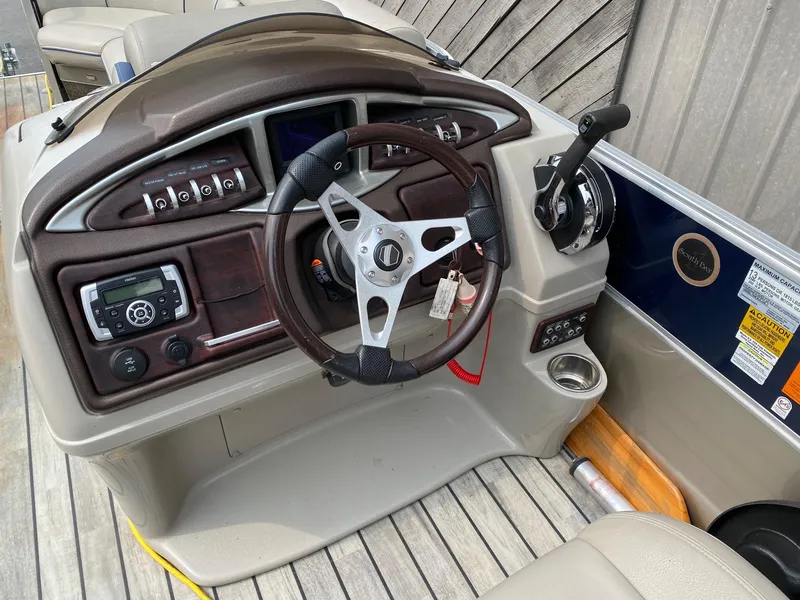 Slide: The Image of 2015 South Bay 724 E boat dashboard with steering wheel and controls. - 2