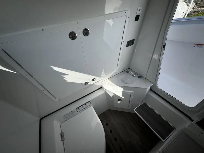 Slide: The Image of Interior of 2025 Sportsman Open 352 boat, featuring compact bathroom amenities. - 25