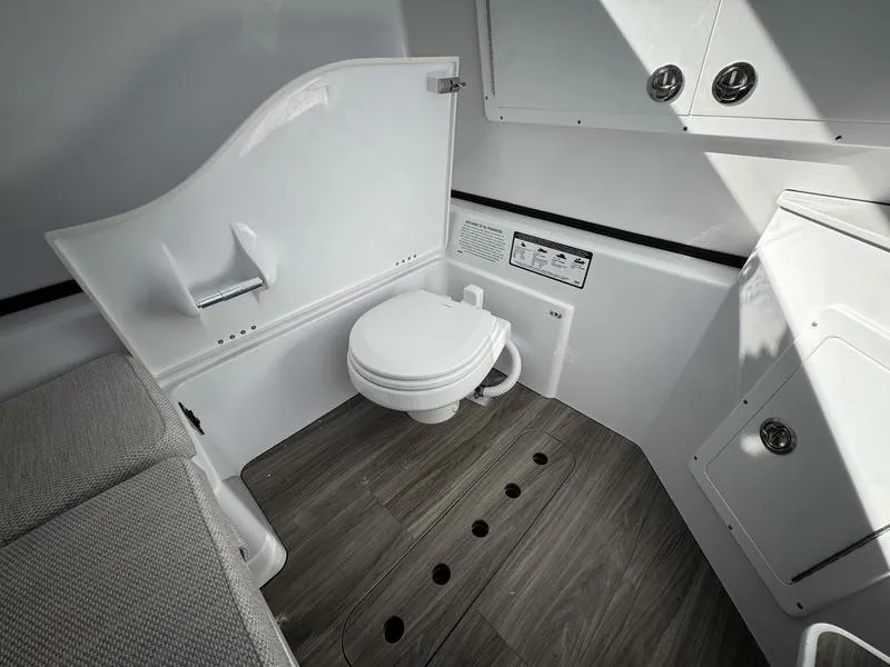 Slide: The Image of 2025 Sportsman Open 352 boat interior with modern bathroom design and wood flooring. - 27