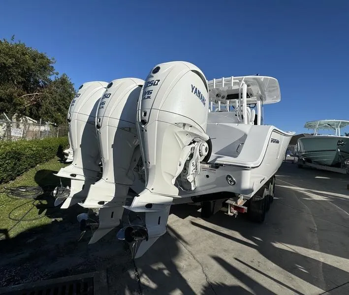 Slide: The Image of 2025 Sportsman Open 352 boat with triple Yamaha outboard engines, parked outdoors. - 4