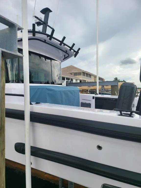 Slide: The Image of 2024 Axopar 37 XC CROSS CABIN boat docked under cloudy skies. - 6