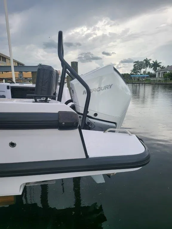 Slide: The Image of 2024 Axopar 37 XC CROSS CABIN with Mercury engine, docked by a serene waterfront. - 7