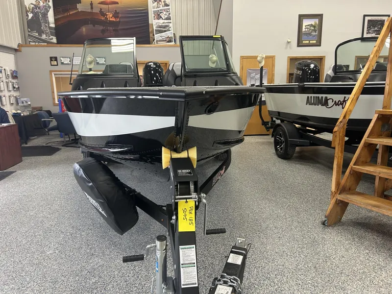 Slide: The Image of 2024 Alumacraft Competitor FSX 185 boat displayed indoors on a trailer. - 1