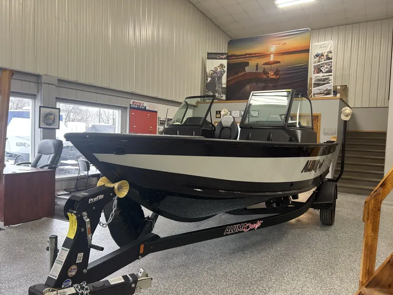 Slide: The Image of 2024 Alumacraft Competitor FSX 185 boat displayed indoors on a trailer. - 2