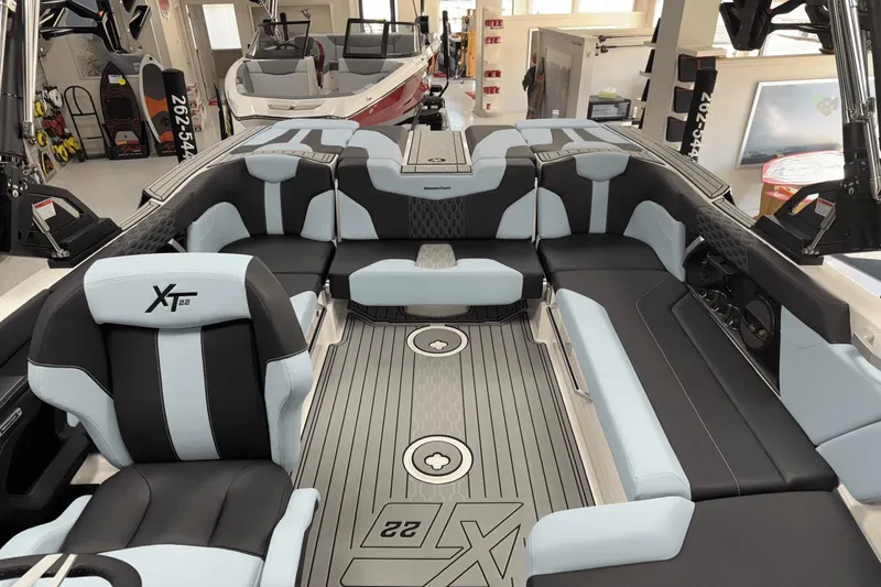 Slide: The Image of 2025 MasterCraft XT22 boat interior with sleek black and light blue seating. - 18