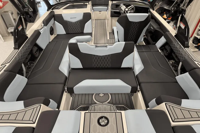 Slide: The Image of 2025 MasterCraft XT22 boat interior with sleek black and gray seating design. - 21