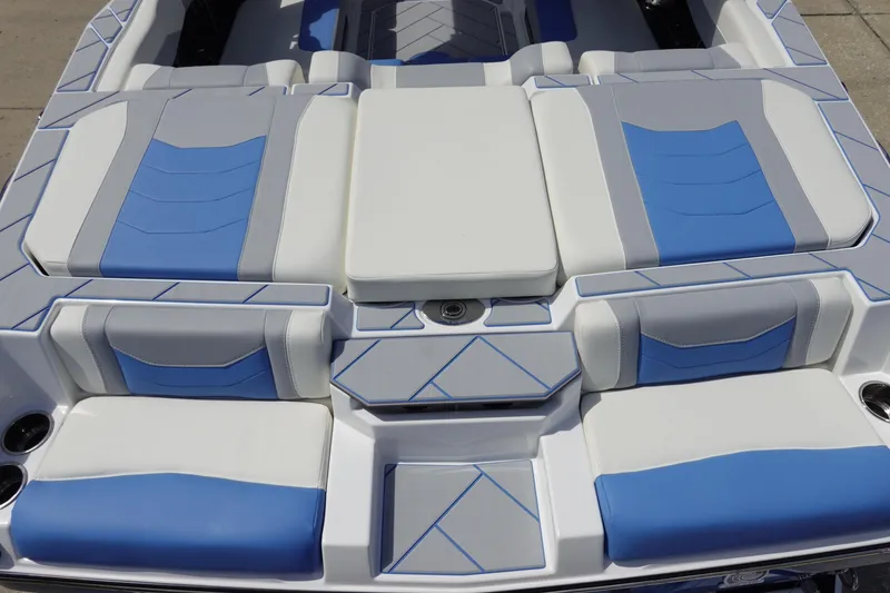 Slide: The Image of 2025 Malibu 23 LSV WAKESETTER boat interior with blue and white cushioned seating. - 10