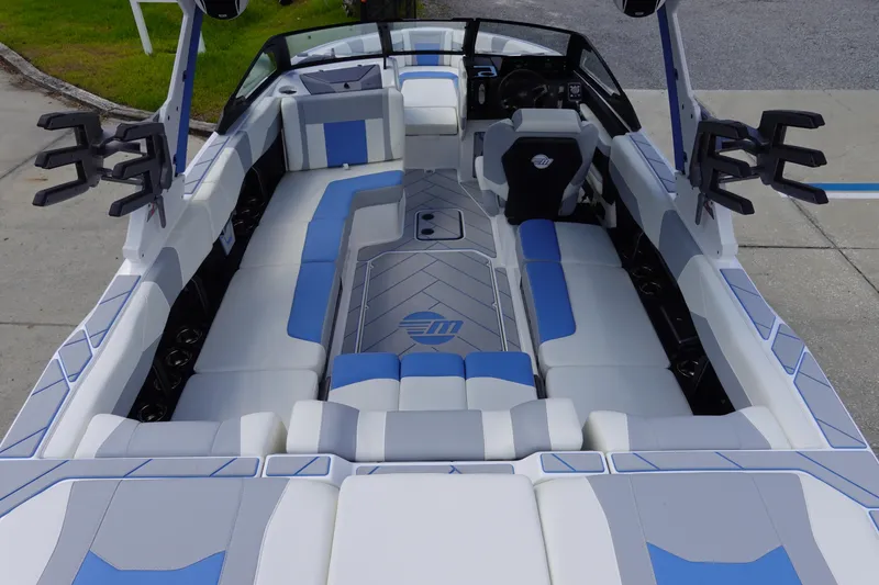 Slide: The Image of 2025 Malibu 23 LSV WAKESETTER boat interior with blue and white seating. - 11