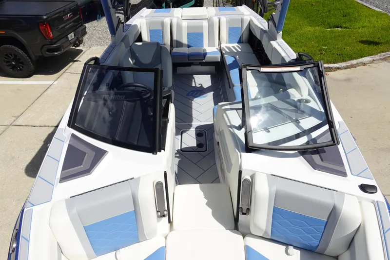 Slide: The Image of 2025 Malibu 23 LSV WAKESETTER boat interior with blue and white seating. - 24