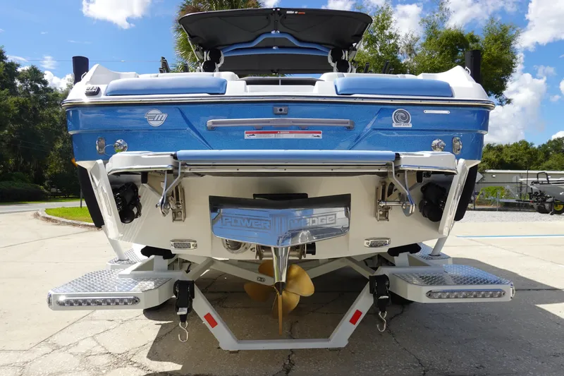 Slide: The Image of 2025 Malibu 23 LSV WAKESETTER boat, rear view, blue and white design. - 9