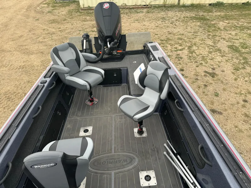 Slide: The Image of 2023 Warrior V2090 boat interior with three seats and motor, parked on grass. - 15