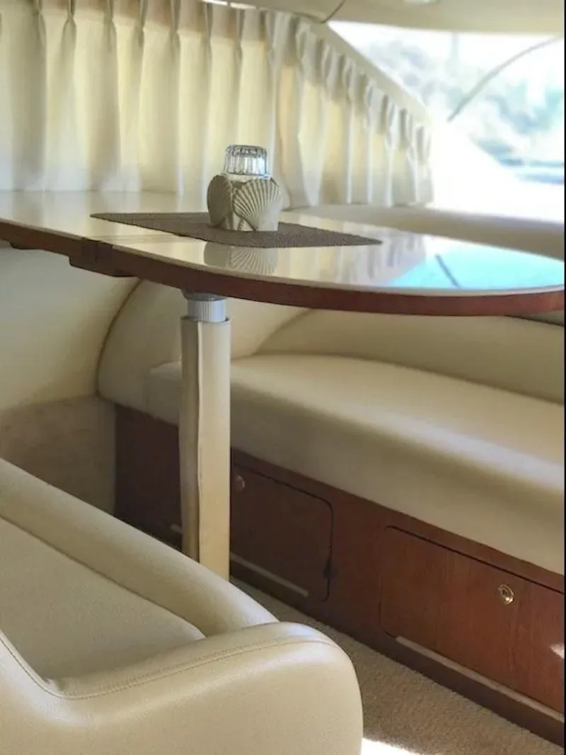 Slide: The Image of Luxurious interior of 2000 Sea Ray 400 Sedan Bridge yacht with elegant seating and table. - 13