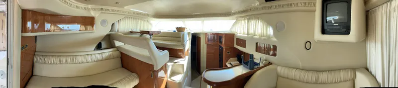 Slide: The Image of Interior of 2000 Sea Ray 400 Sedan Bridge yacht, featuring elegant seating and wood accents. - 6
