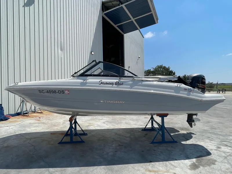 Slide: The Image of 2021 Stingray 191 DC boat on stands outside a large building. - 1