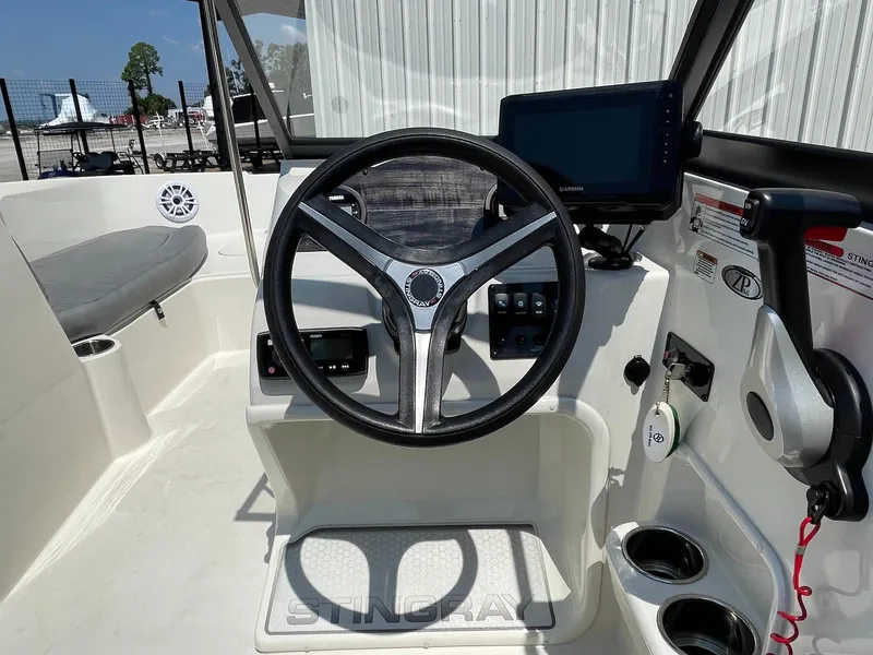 Slide: The Image of 2021 Stingray 191 DC boat cockpit with steering wheel, control panel, and navigation screen. - 4