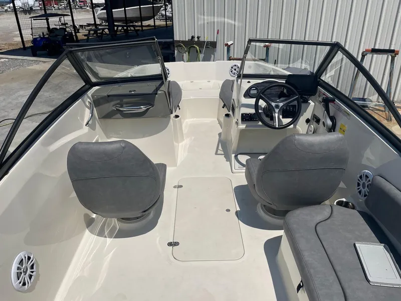 Slide: The Image of 2021 Stingray 191 DC boat interior with gray seating and steering console. - 5