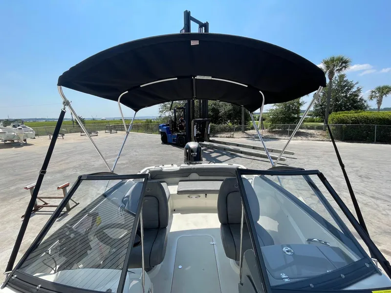 Slide: The Image of 2021 Stingray 191 DC boat with black canopy and windshield, parked outdoors. - 8