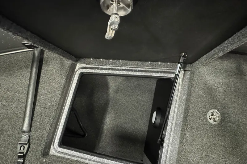 Slide: The Image of Open storage compartment in 2024 Nitro ZV20 boat, featuring secure latch and carpeted interior. - 14