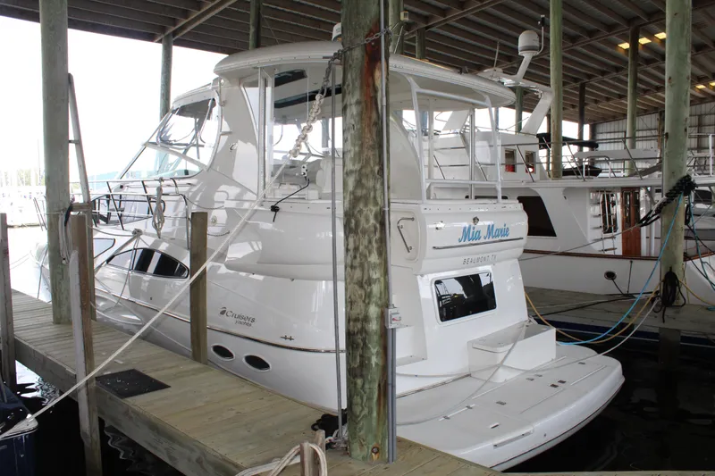 Slide: The Image of 2005 Cruisers 455 Express Motor Yacht docked in a covered marina. - 0