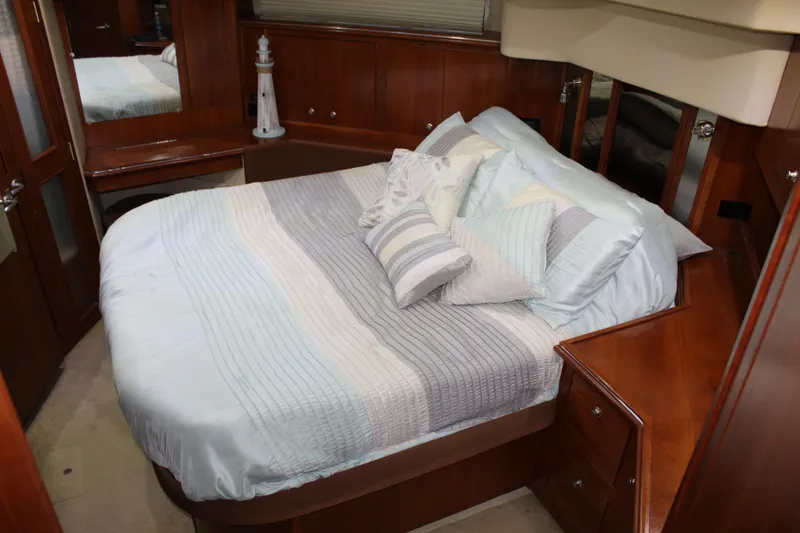 Slide: The Image of Luxurious bedroom in 2005 Cruisers 455 Express Motor Yacht with elegant bedding and wood accents. - 23