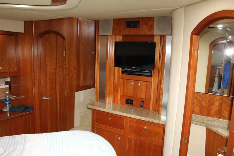 Slide: The Image of Luxurious 2005 Cruisers 455 Express Motor Yacht interior with wood cabinetry and TV. - 29