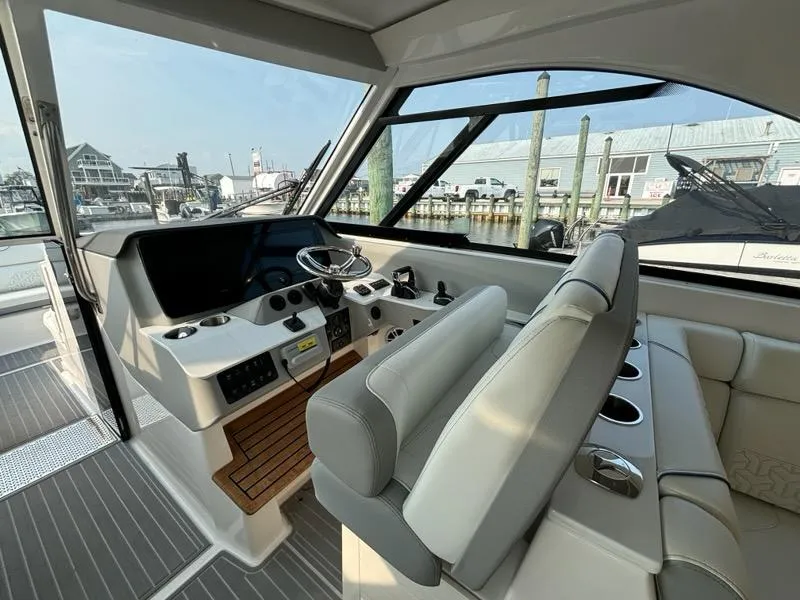 Slide: The Image of 2022 Regal LX36 boat interior with modern helm and seating at marina. - 13