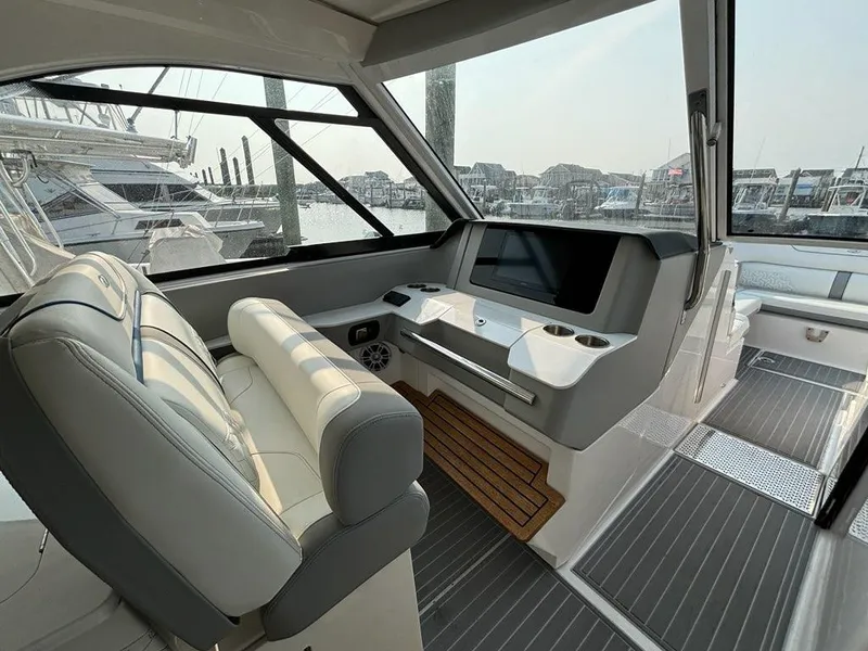 Slide: The Image of 2022 Regal LX36 boat interior with modern dashboard and seating at marina. - 14