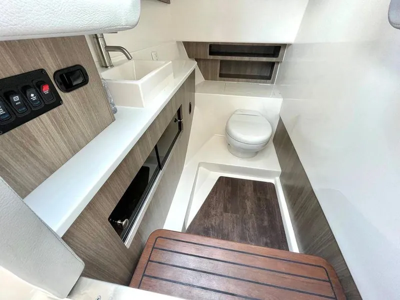 Slide: The Image of 2022 Regal LX36 boat interior bathroom with sink, toilet, and wood accents. - 26
