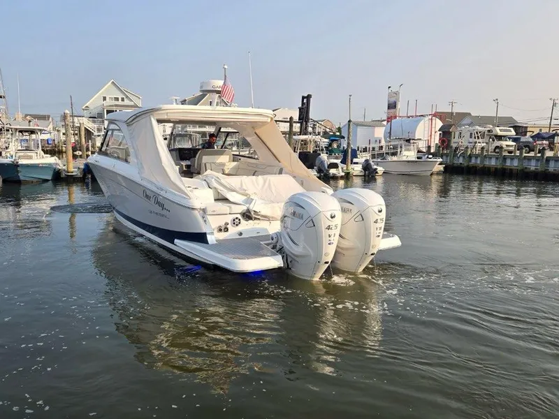 Slide: The Image of 2022 Regal LX36 boat with twin outboard engines docked in a marina. - 5