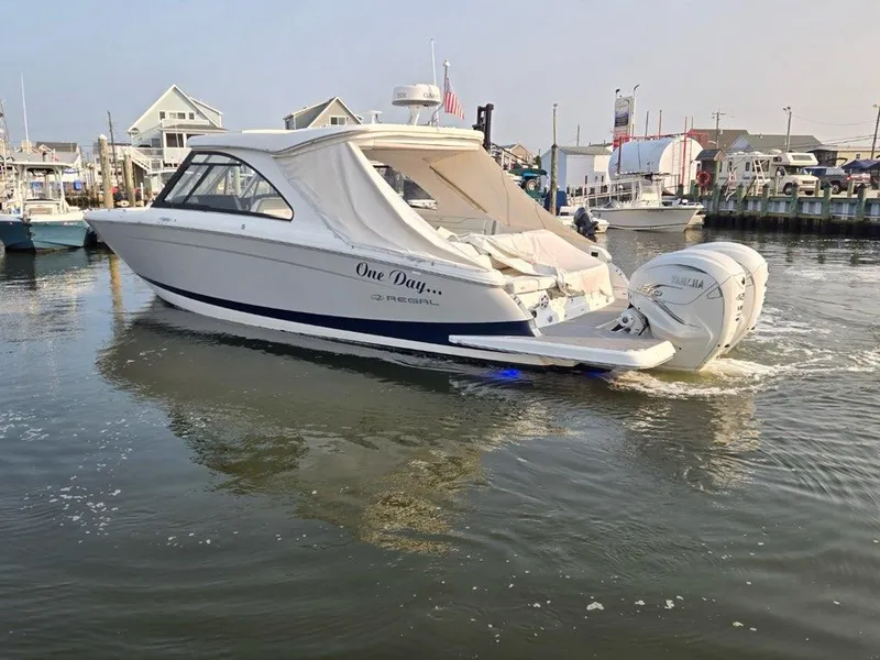 Slide: The Image of 2022 Regal LX36 boat docked in a marina, featuring sleek design and powerful outboard engines. - 6