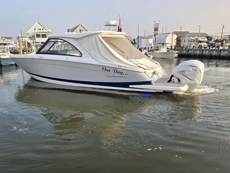 Slide: The Image of 2022 Regal LX36 boat docked in a marina, featuring sleek design and outboard motor. - 8