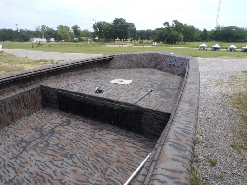 Slide: The Image of 2024 Xpress HD15DBX boat with camouflage design in a rural setting. - 10