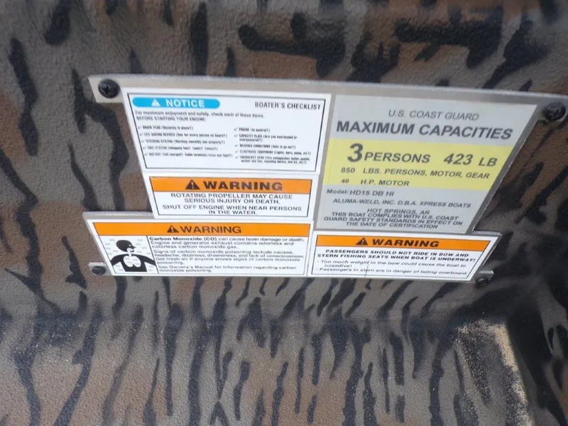 Slide: The Image of Warning labels on 2024 Xpress HD15DBX boat, detailing capacity and safety instructions. - 7