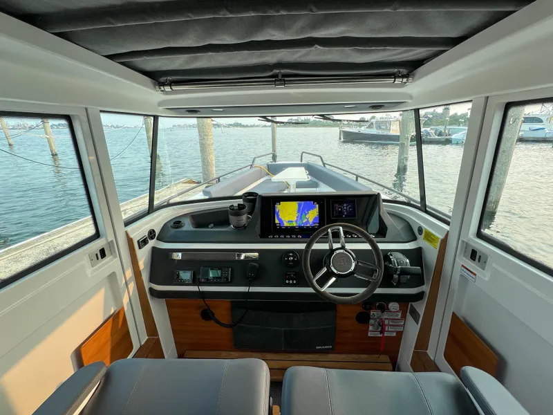Slide: The Image of Interior view of 2020 Axopar 28 CABIN boat with modern dashboard and steering. - 11
