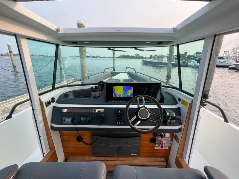 Slide: The Image of Axopar 28 CABIN 2020 boat interior with steering wheel and navigation system. - 12