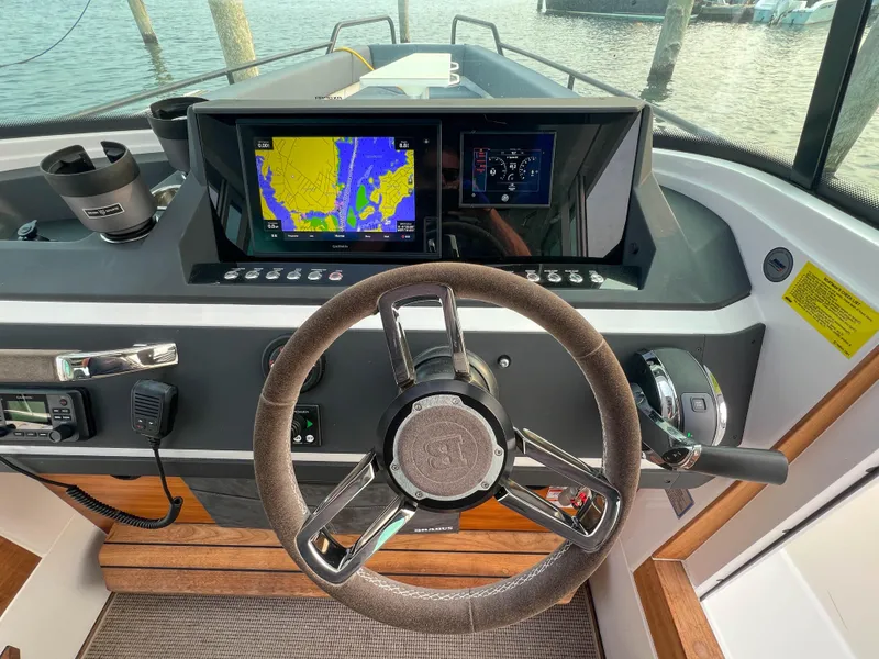 Slide: The Image of Axopar 28 CABIN 2020 helm with navigation screens and steering wheel. - 14