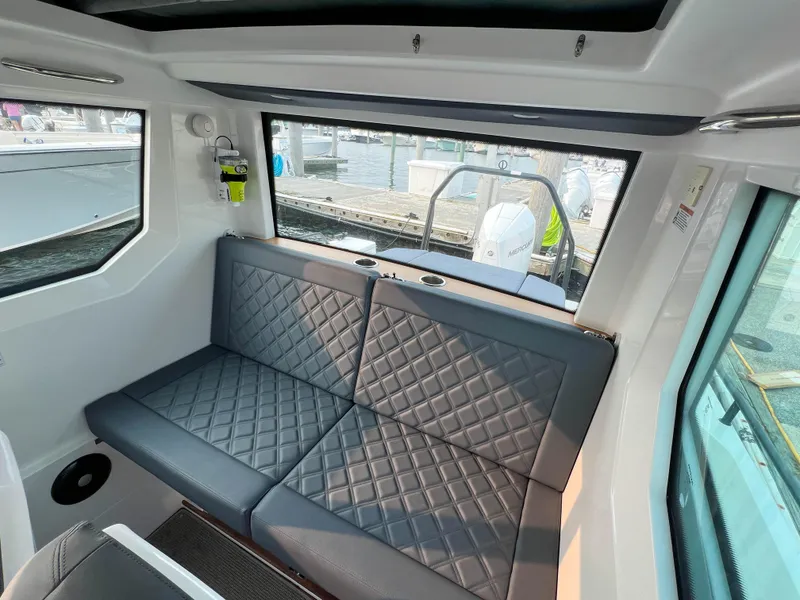 Slide: The Image of Interior of 2020 Axopar 28 CABIN with quilted seating and large windows. - 16