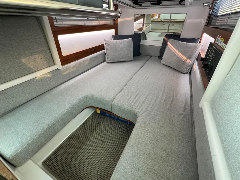 Slide: The Image of Interior of 2020 Axopar 28 CABIN with gray seating and cushions. - 18
