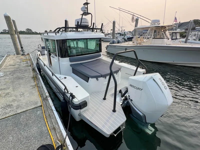 Slide: The Image of 2020 Axopar 28 CABIN boat docked with Mercury outboard engine. - 2