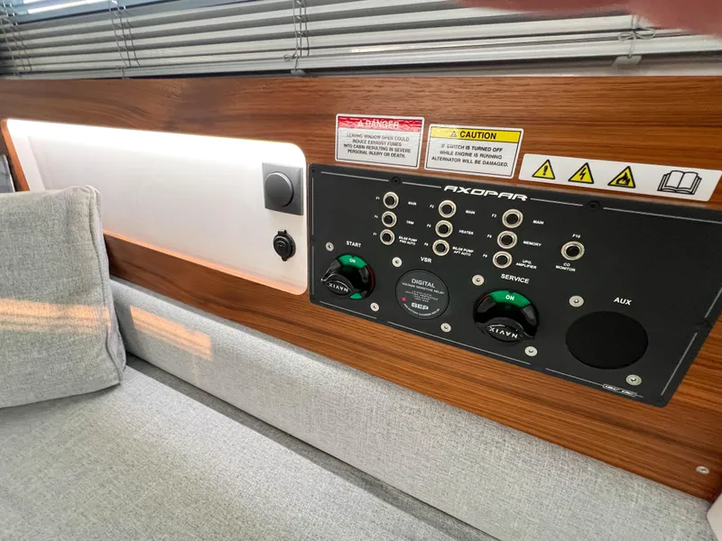 Slide: The Image of Control panel inside 2020 Axopar 28 CABIN boat with wood finish and cushioned seating. - 20