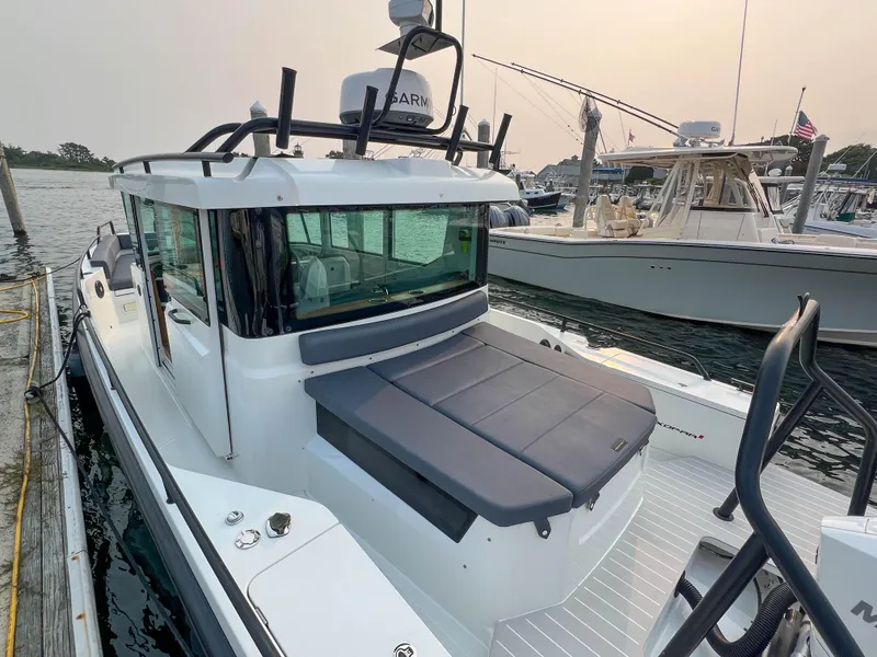 Slide: The Image of 2020 Axopar 28 CABIN boat docked in marina, featuring sleek design and spacious cabin. - 4