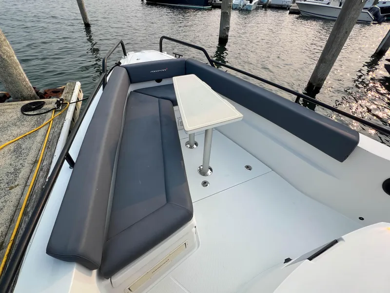 Slide: The Image of 2020 Axopar 28 CABIN boat with seating and table, docked by the water. - 7