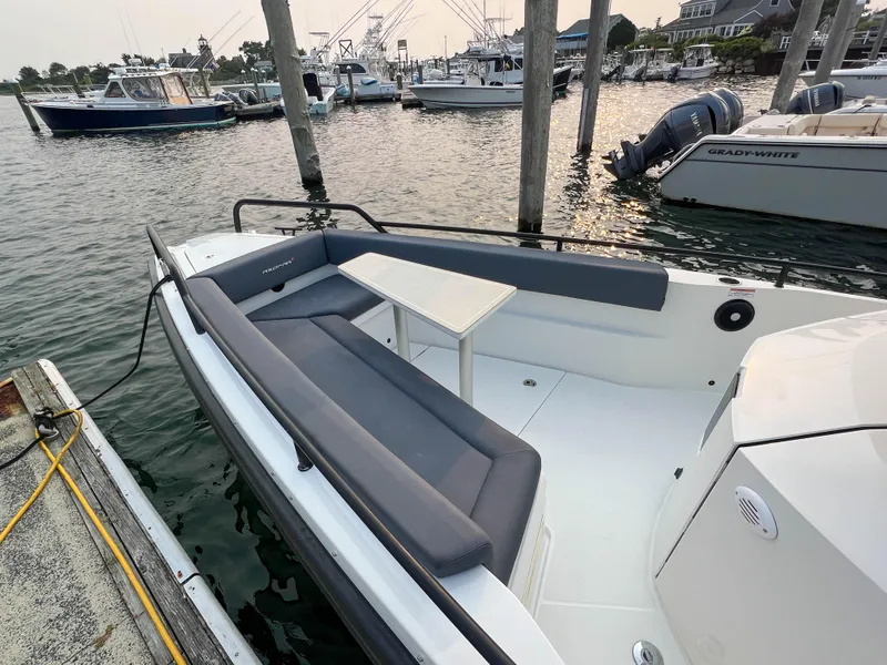 Slide: The Image of 2020 Axopar 28 CABIN boat docked, featuring spacious seating and table. - 8