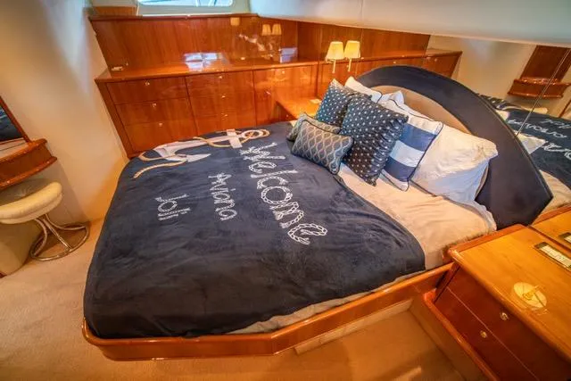 Slide: The Image of Luxurious 2005 Neptunus 62 Flybridge yacht bedroom with elegant bedding and wooden cabinetry. - 13