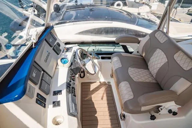 Slide: The Image of 2005 Neptunus 62 Flybridge helm with luxurious seating and advanced navigation controls. - 14
