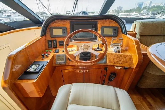 Slide: The Image of Luxurious 2005 Neptunus 62 Flybridge yacht helm with wood finish and modern controls. - 2